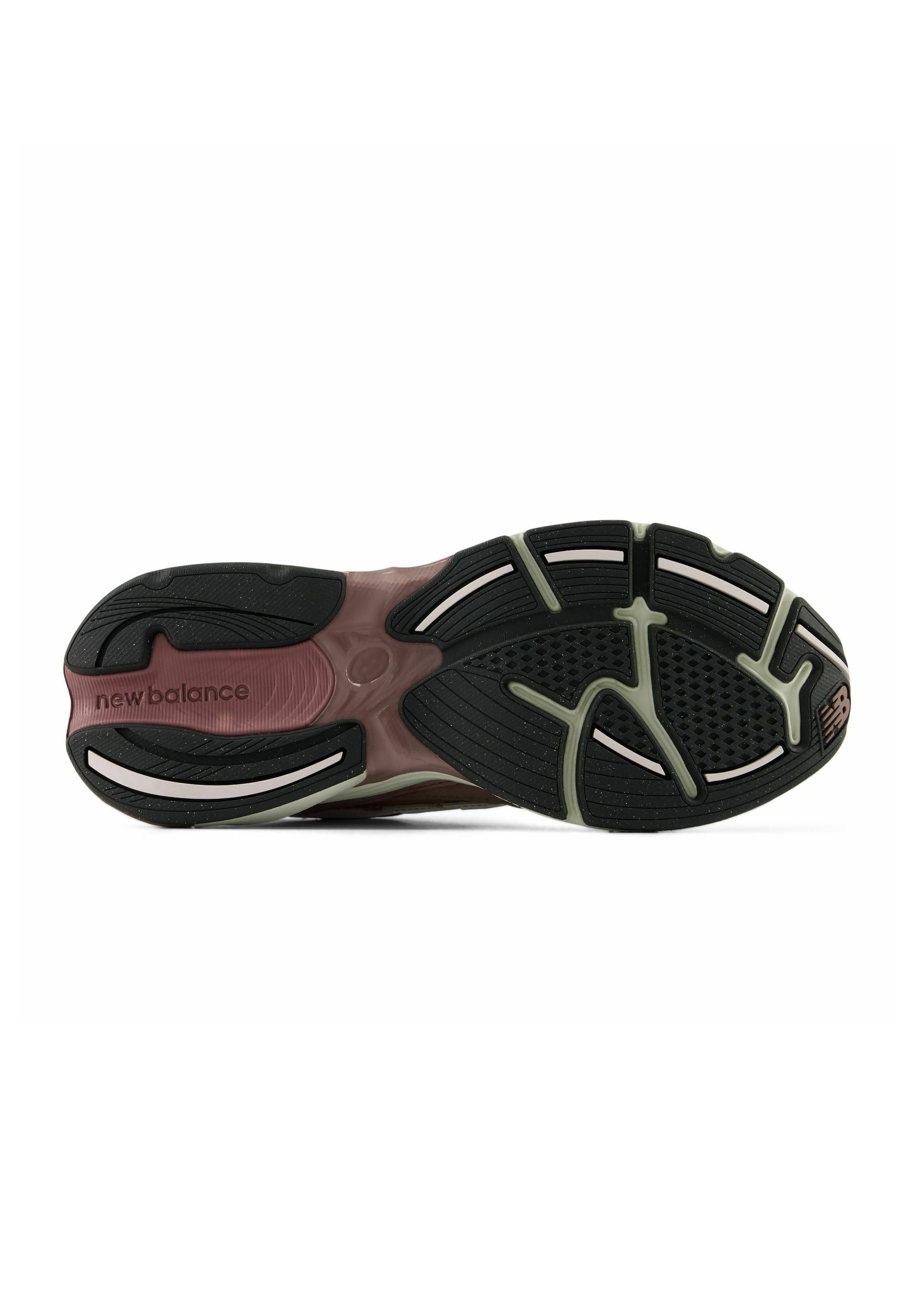 Suela de zapatilla New Balance mostrando una suela negra y marrón con agarre texturizado y el nombre de la marca cerca del talón.