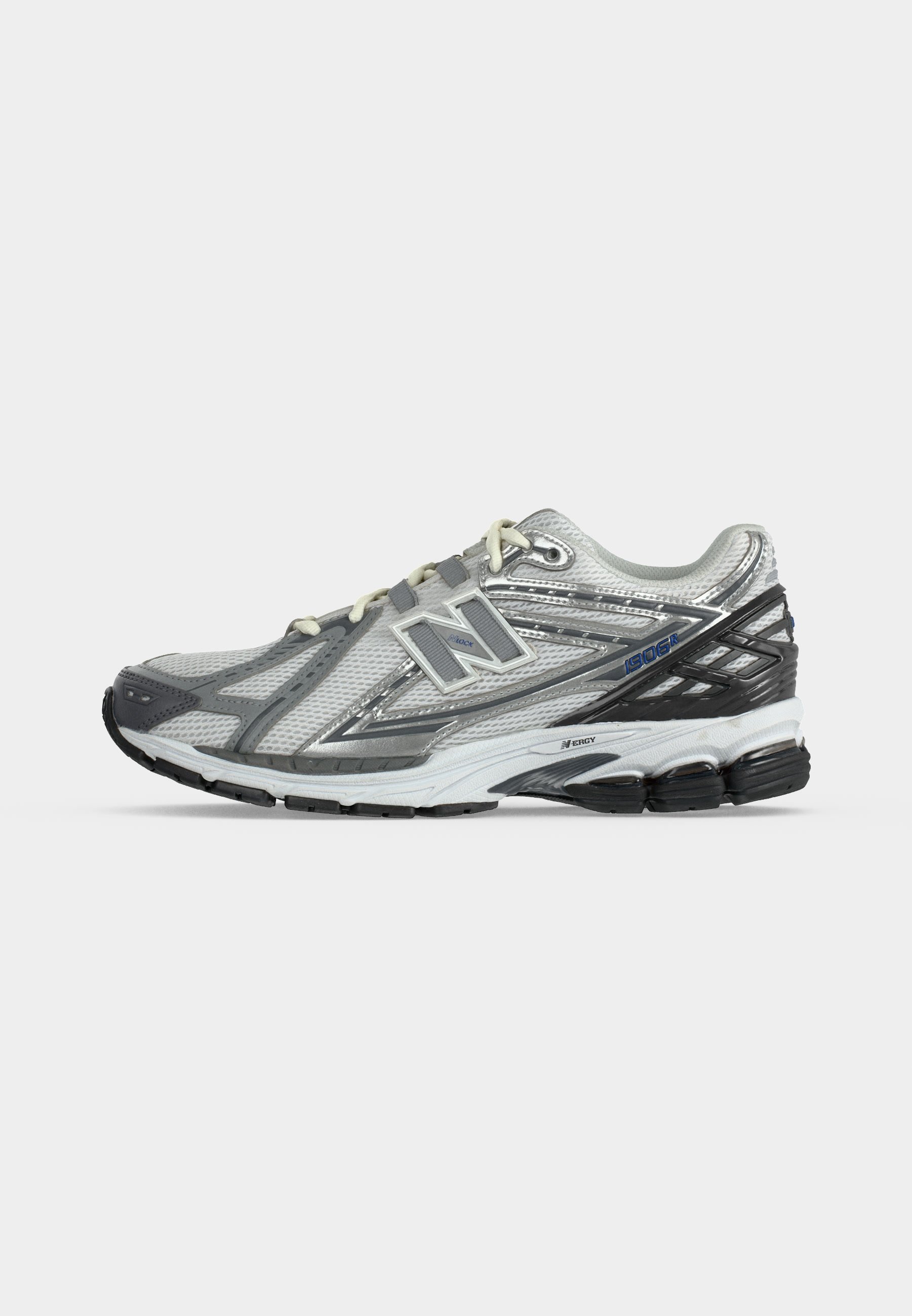 Zapatilla de correr New Balance blanca y gris con parte superior de malla, suela acolchada y suela exterior de goma negra, mostrada de perfil sobre fondo neutro.