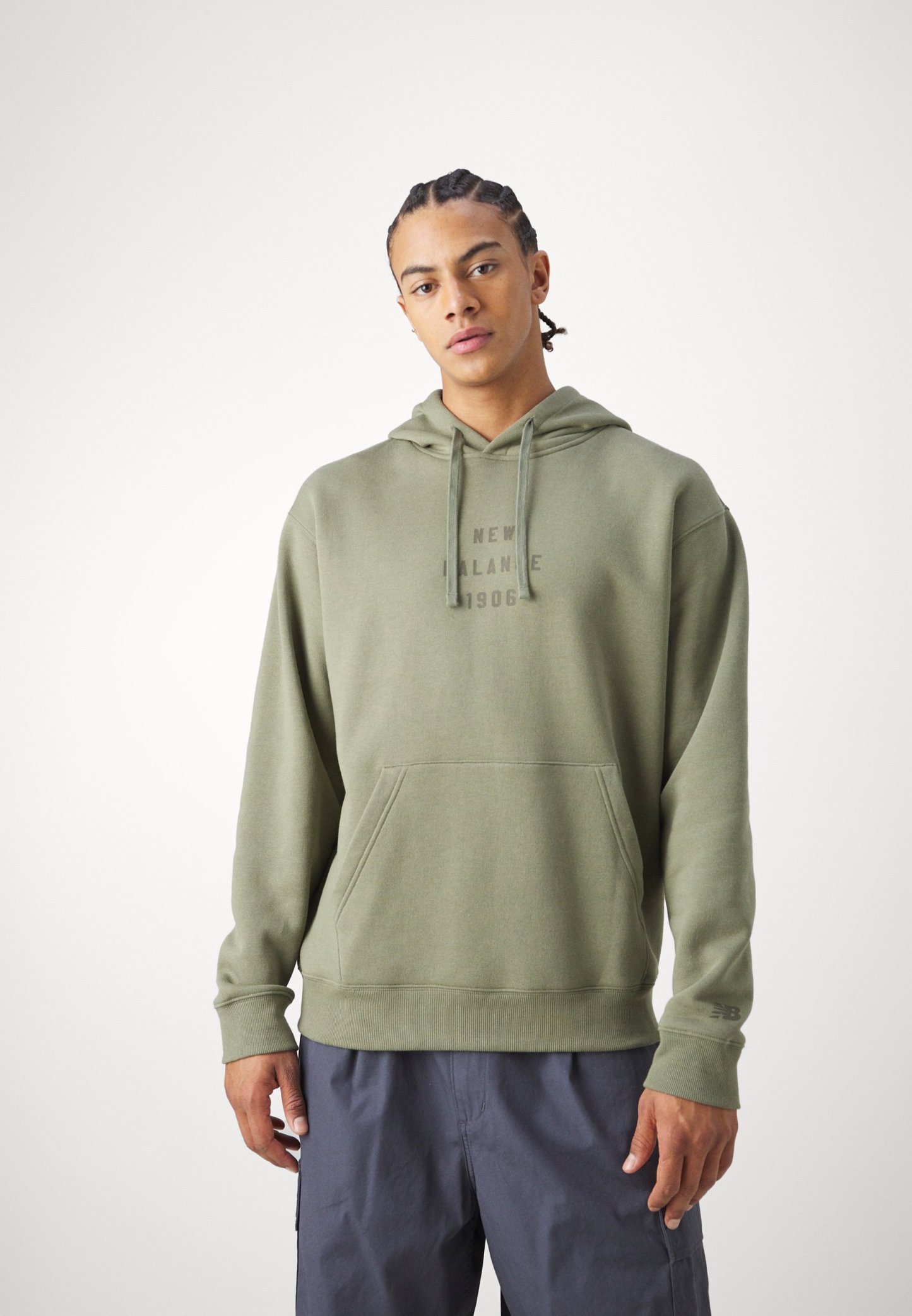 Sudadera verde oliva de mezcla de algodón, con bolsillo tipo canguro, cintas ajustables y logo de New Balance en el frente.