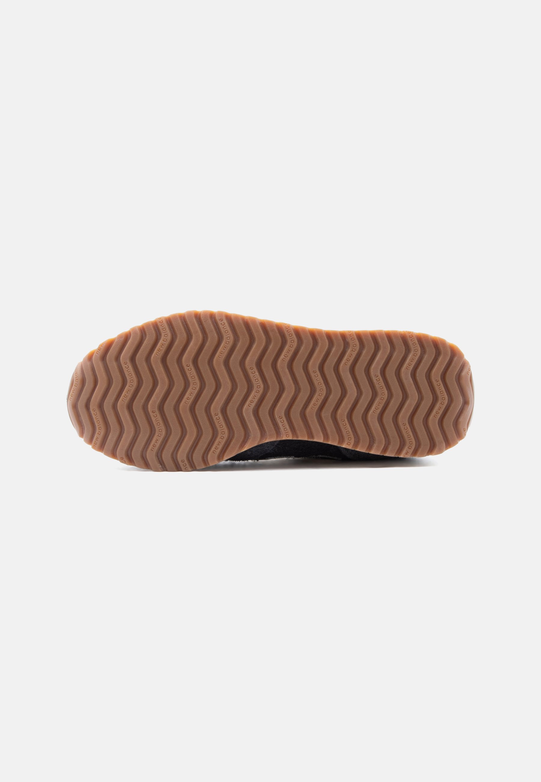 Suela de zapato con banda de rodadura de goma marrón que presenta un patrón en zigzag y pequeño texto de la marca en cada cresta, mostrado sobre un fondo blanco.
