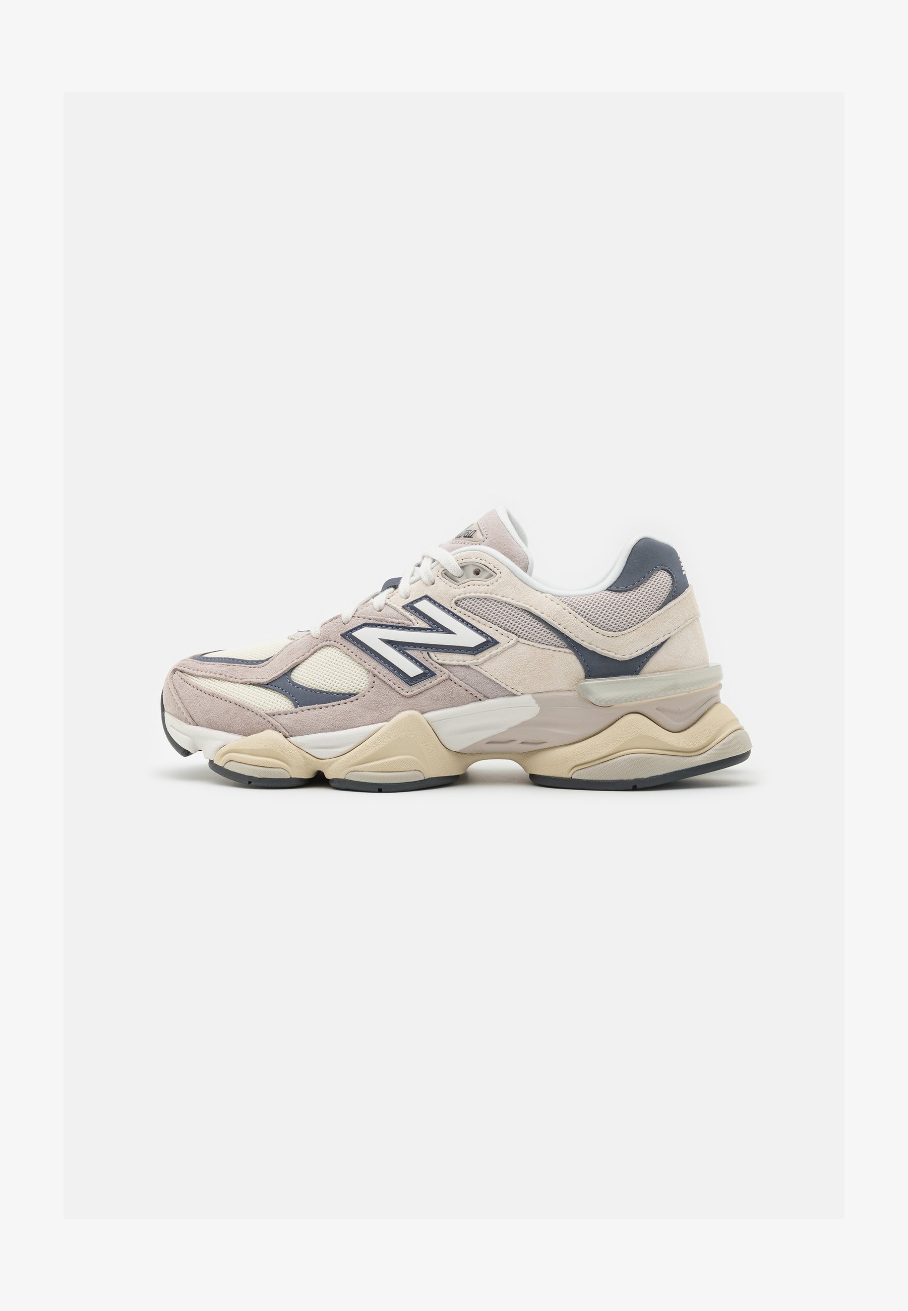 Zapatillas de deporte en rosa claro y beige, con materiales de malla y ante. Presentan un logo blanco, superposiciones texturizadas y una suela acolchada. Forma redondeada.