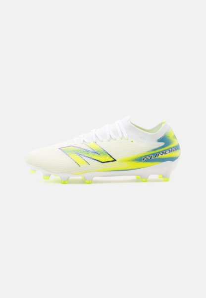 Bota de fútbol blanca con detalles en amarillo y azul, cordones y suela con tacos diseñada para jugar en terreno firme.