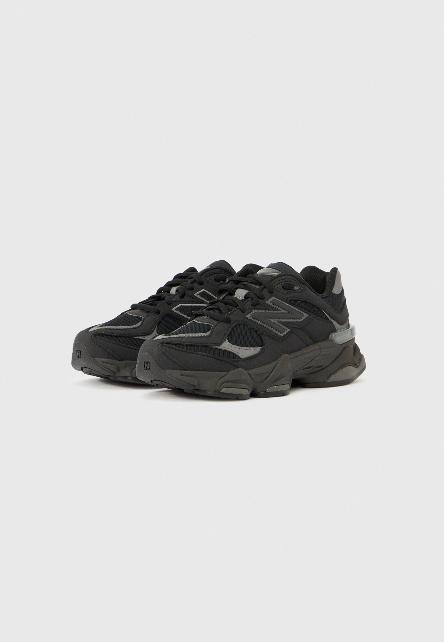 Zapatillas deportivas negras con parte superior texturizada, que combinan malla y materiales sintéticos. Detalles reflectantes y diseño de suela gruesa.