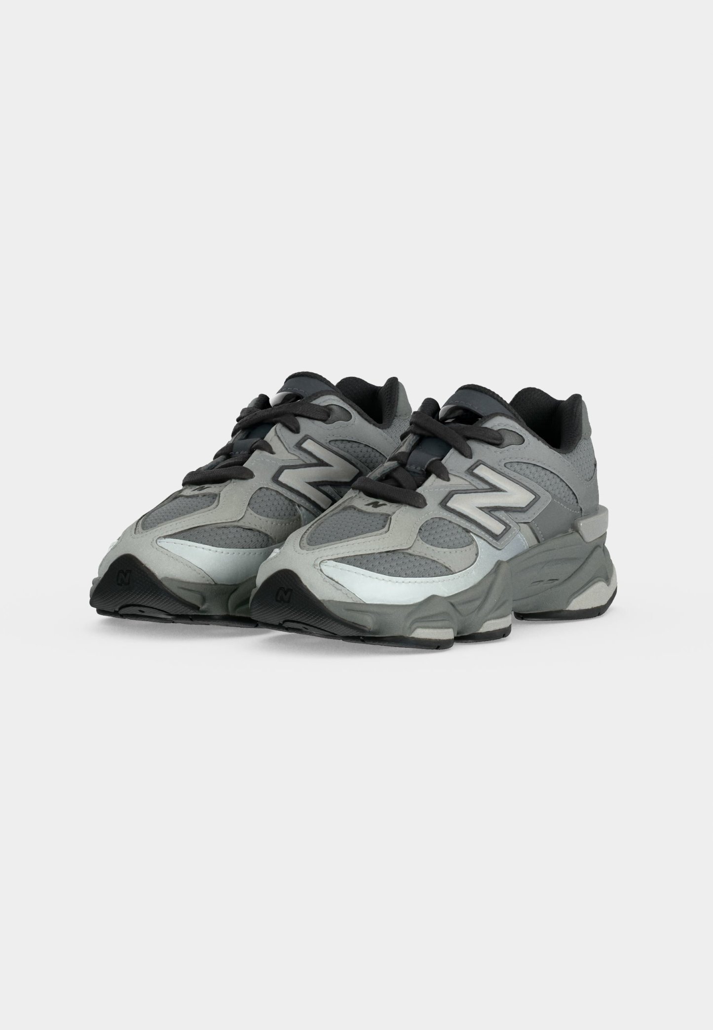 Zapatillas deportivas New Balance en gris y negro con parte superior de malla y sintética, cordones negros y suela gruesa acolchada, mostradas desde un ángulo frontal.