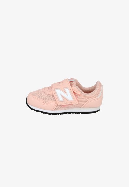 Pequeña zapatilla infantil rosa con el logo blanco de New Balance, empeine de malla y material sintético, y suela negra con media suela blanca.
