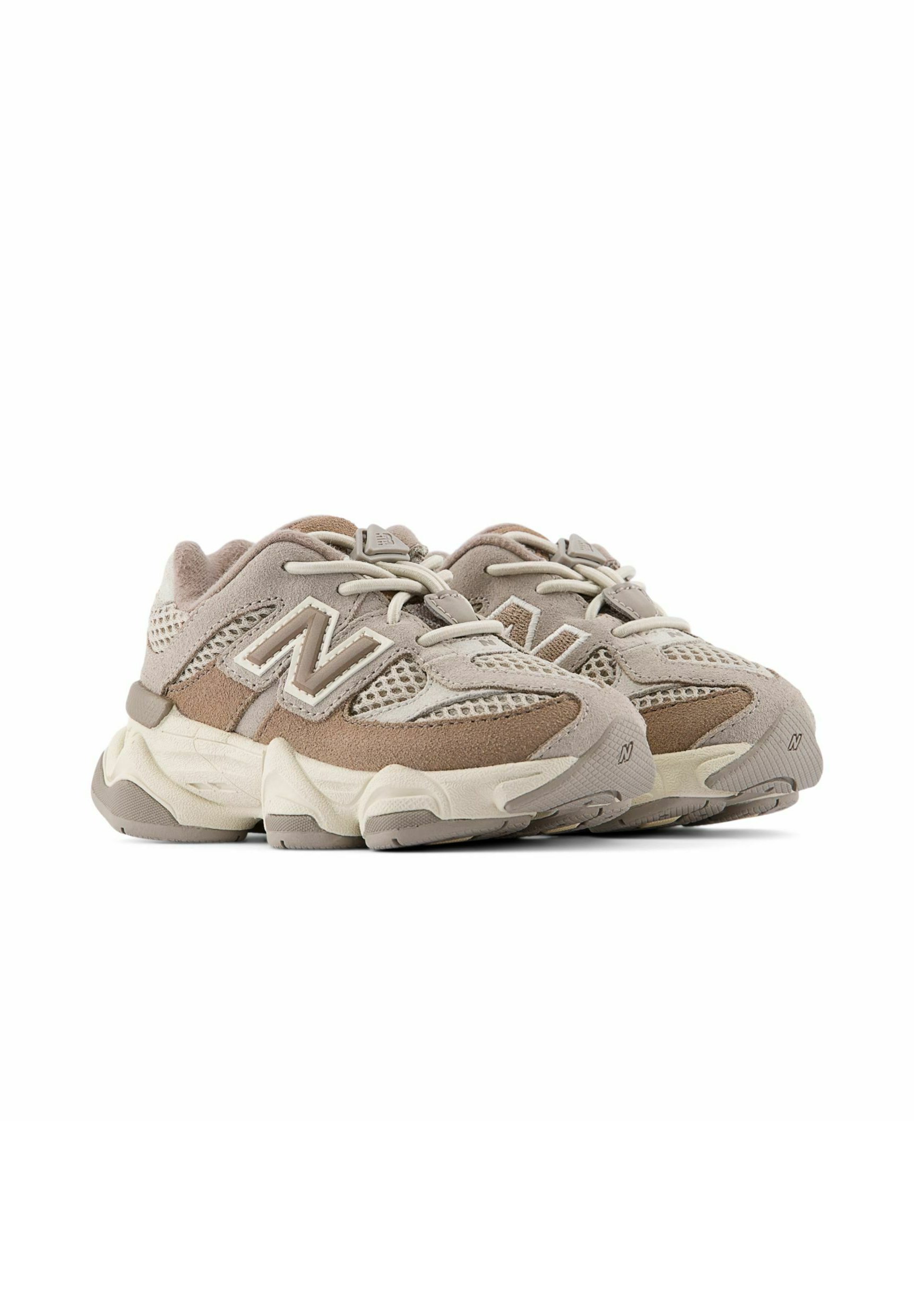 Par de zapatillas deportivas New Balance beige y marrón claro con empeines de malla y ante y suelas gruesas y acolchadas.