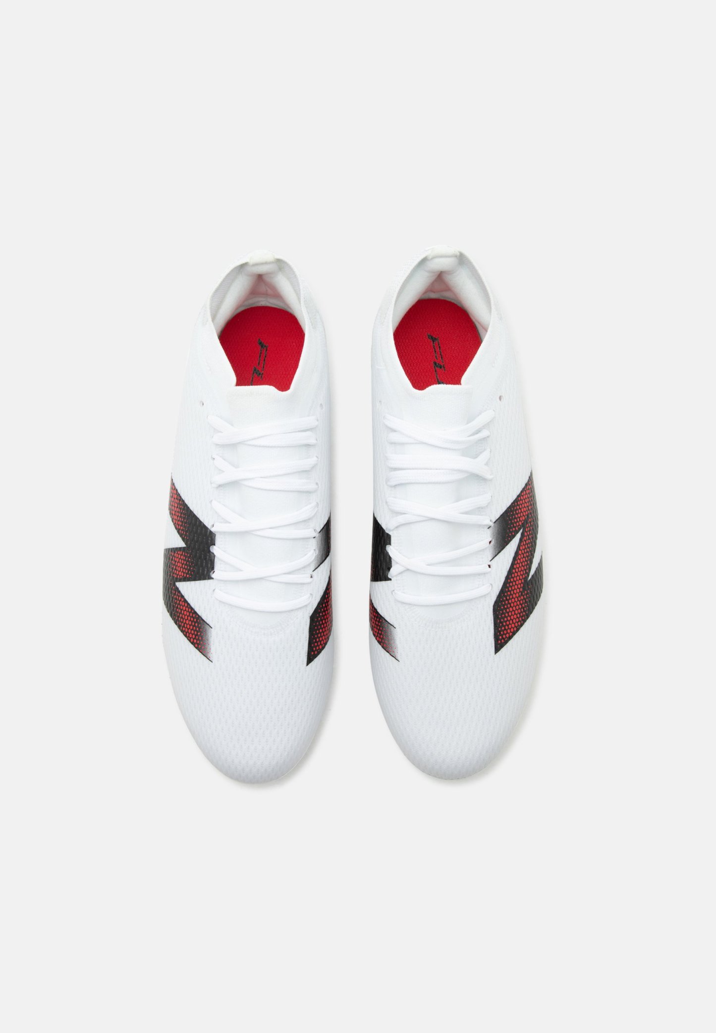 Zapatillas deportivas blancas con cordones, con diseño geométrico negro y rojo en los laterales y plantillas rojas, vistas desde arriba sobre un fondo blanco.