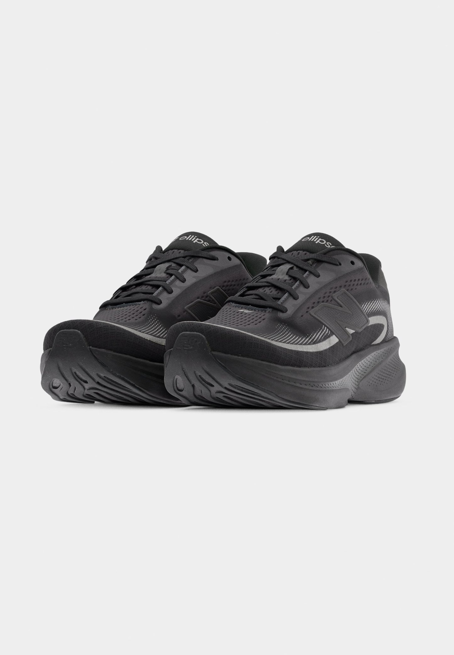 Zapatillas deportivas negras con parte superior de malla, cuello acolchado y patrones texturizados en la suela. Cordones y detalles de la marca en un gris contrastante.