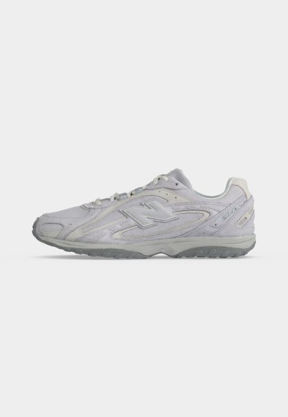Zapatilla deportiva blanca New Balance 2041 con suela gris, detalles cosidos, cuello acolchado y cierre de cordones, mostrada en perfil lateral.