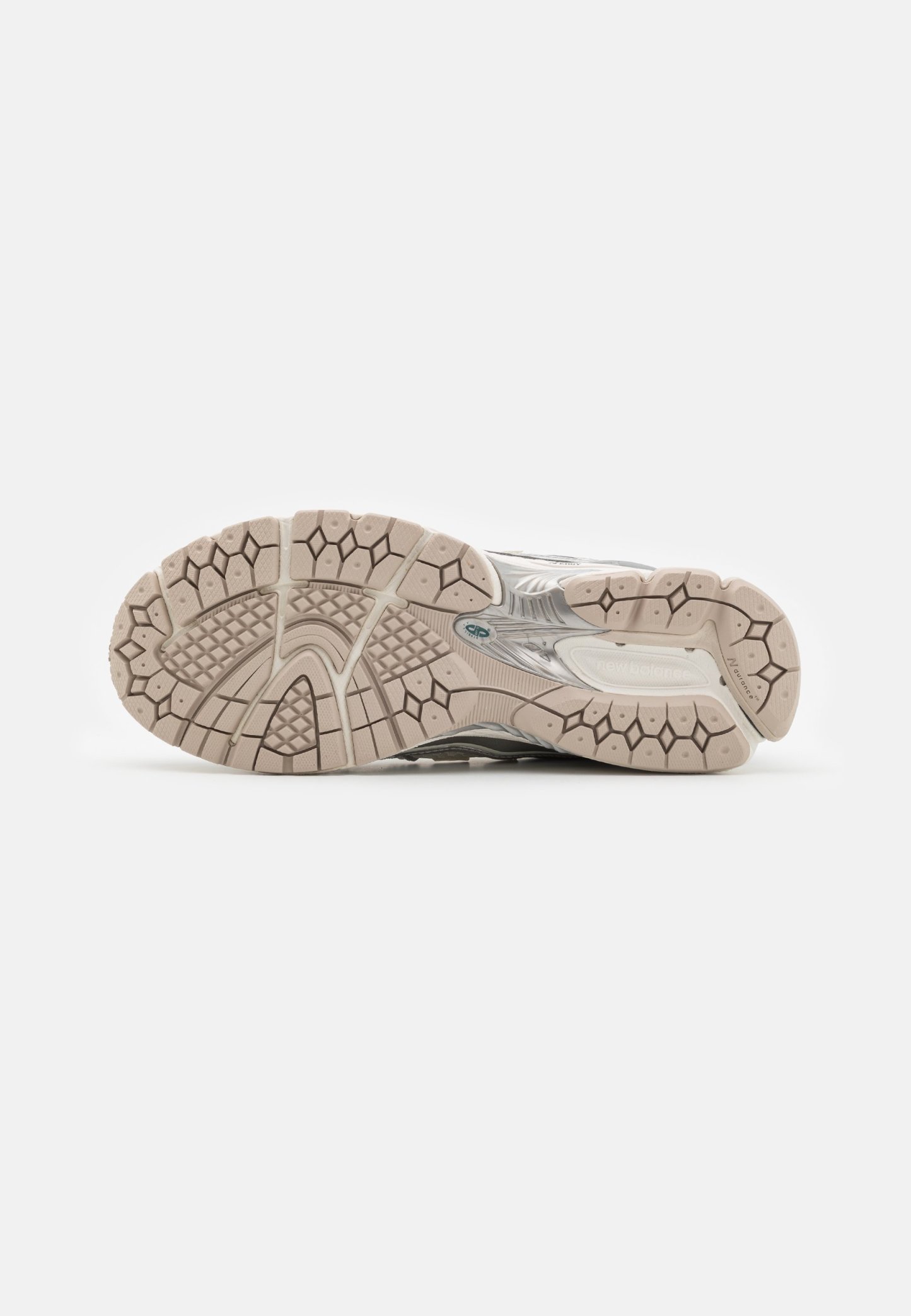 Suela de zapato con un diseño de goma texturizada, que presenta un color beige claro y un patrón de tacos hexagonales y circulares para tracción.