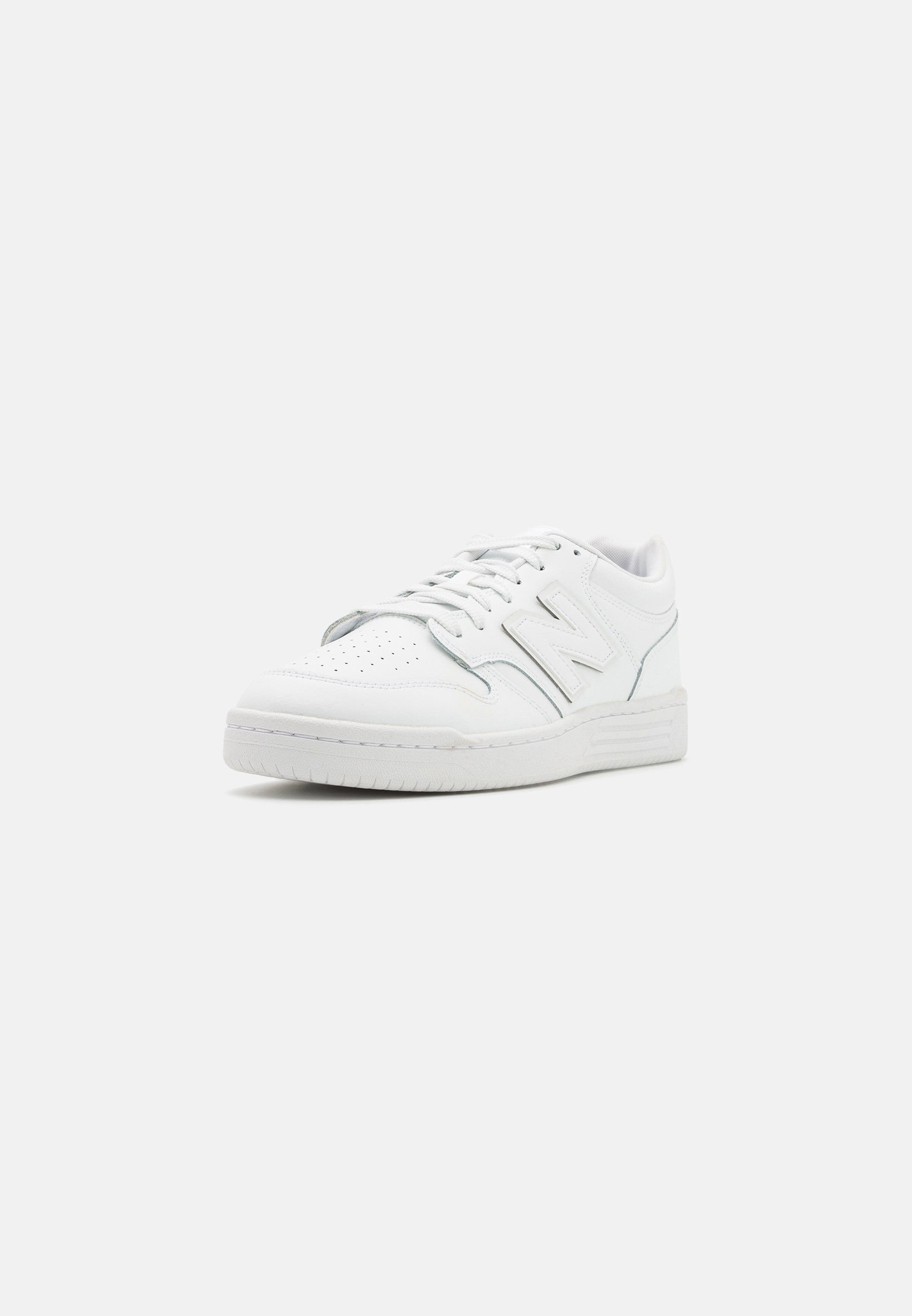 Zapatillas de cuero blancas con puntera perforada, cordones planos, acento del logo N en el lateral y suela de goma. Diseño clásico de puntera redonda y perfil bajo.