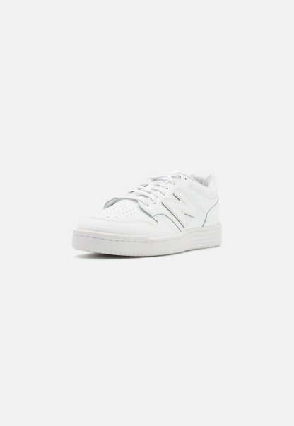 Zapatillas de cuero blancas con puntera perforada, cordones planos, acento del logo N en el lateral y suela de goma. Diseño clásico de puntera redonda y perfil bajo.