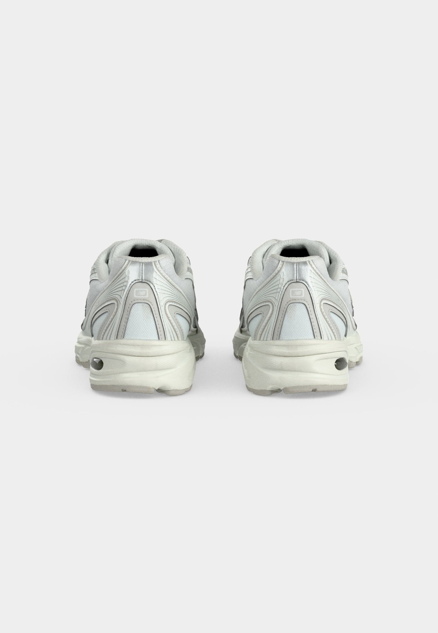 Par de zapatillas deportivas blancas con suelas gruesas mostradas desde atrás sobre un fondo blanco liso.
