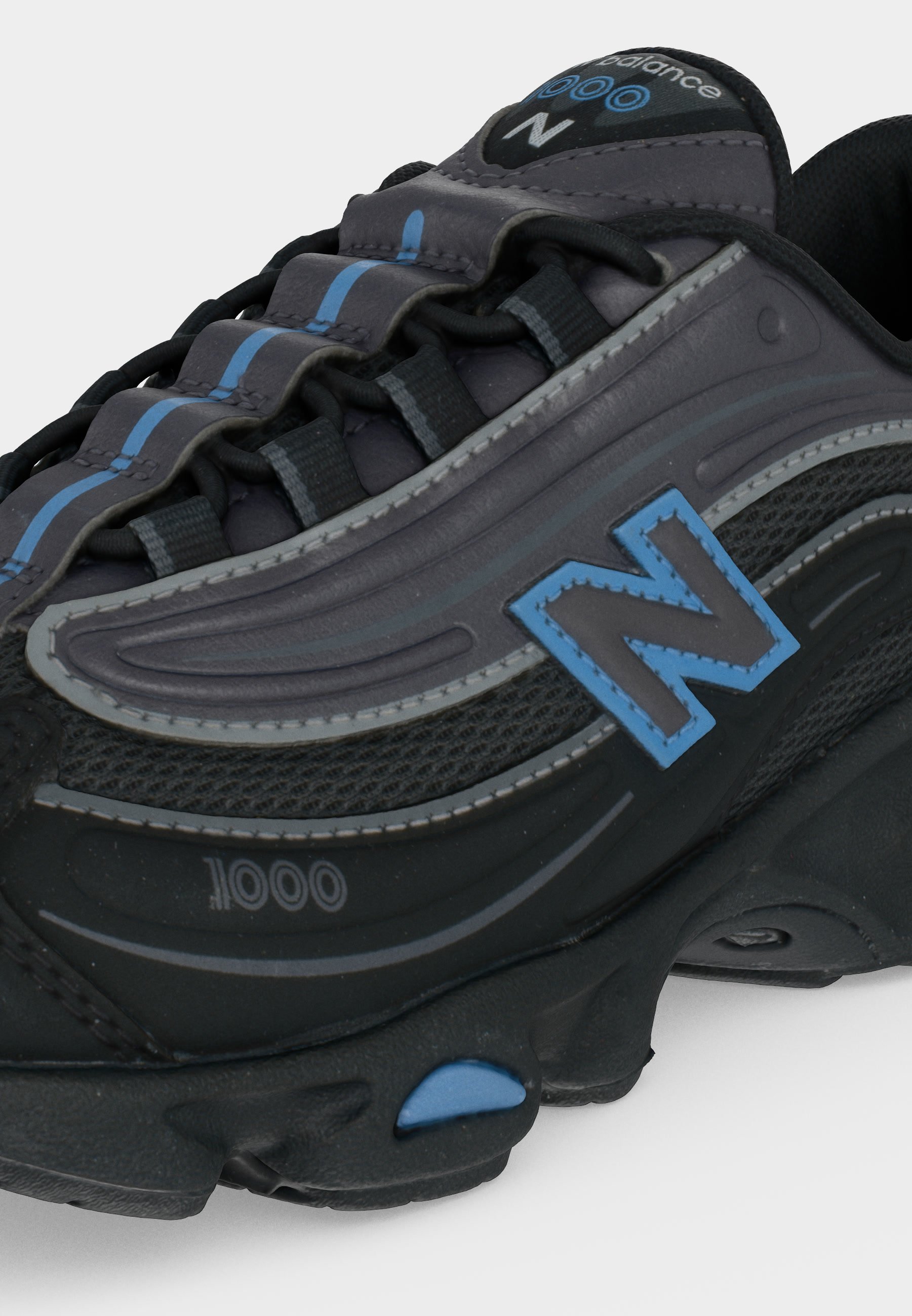 Zapatilla New Balance 1000 negra y gris con detalles azules y paneles de malla, mostrada en una vista lateral en primer plano.