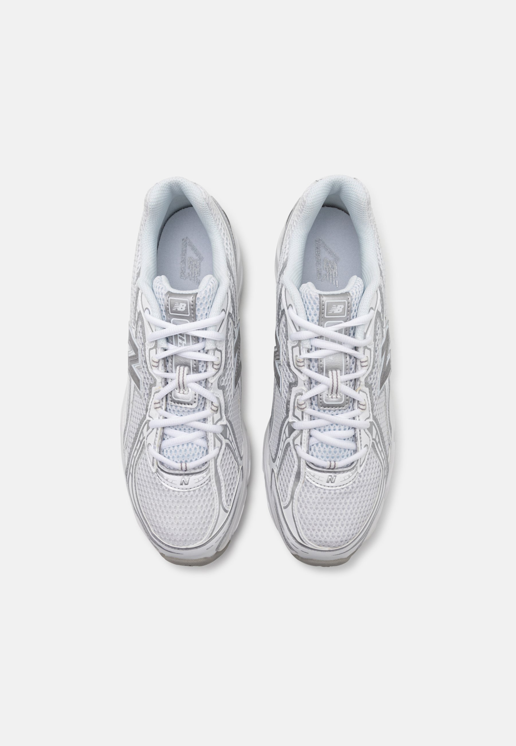 Zapatillas deportivas blancas con parte superior de malla, con acentos grises y detalles reflectantes, diseño con cordones, cuello acolchado y suela texturizada.