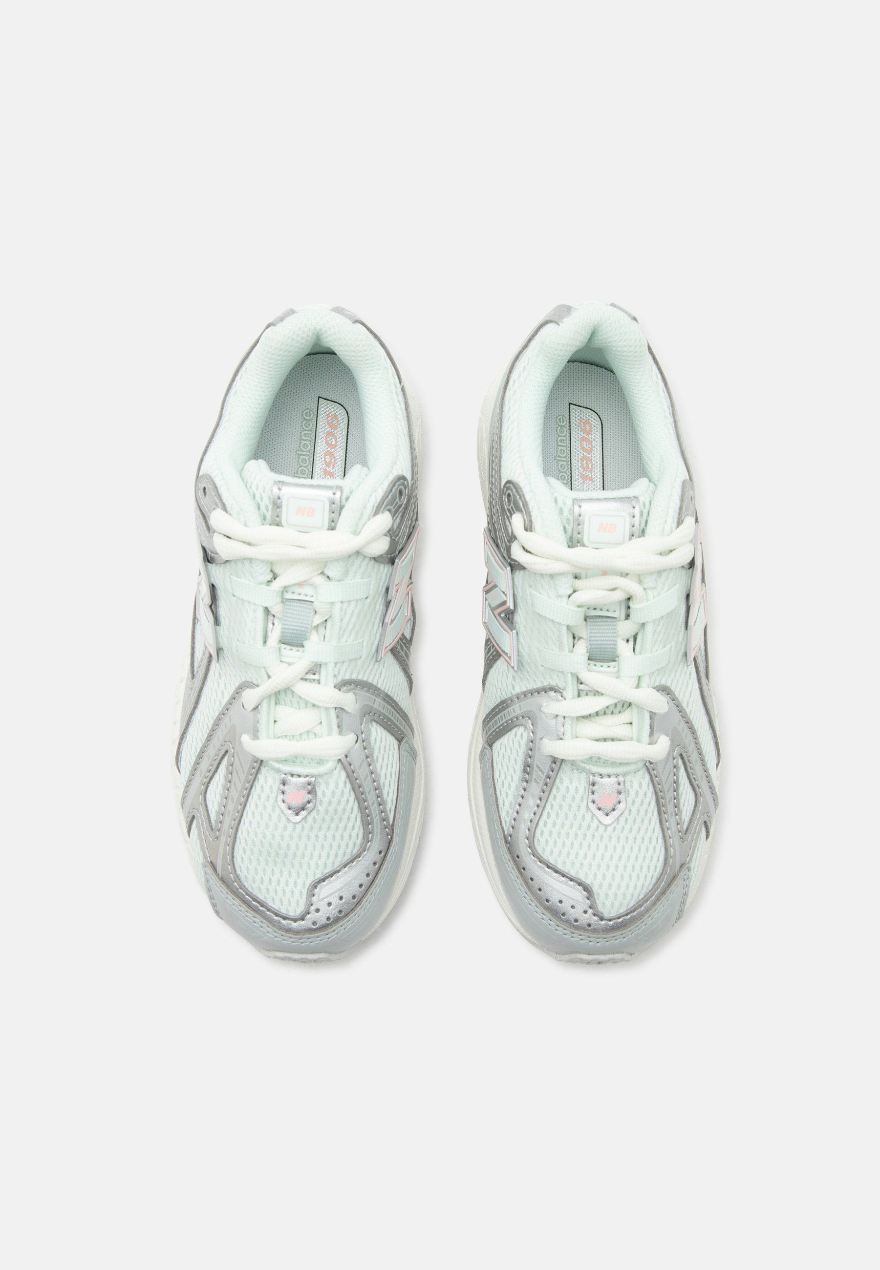 Par de zapatillas de correr New Balance gris claro y blanco con diseño de malla y cordones, vistas desde arriba sobre un fondo blanco.