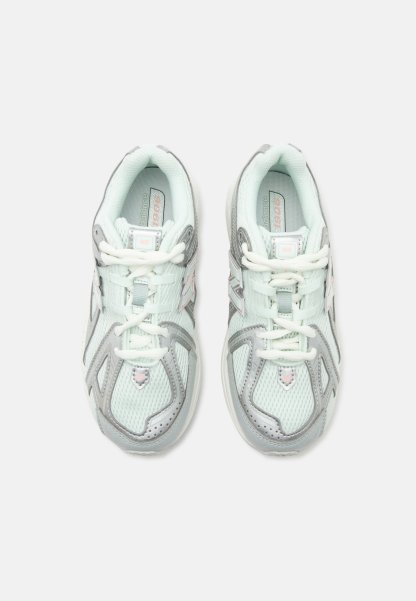Par de zapatillas de correr New Balance gris claro y blanco con diseño de malla y cordones, vistas desde arriba sobre un fondo blanco.