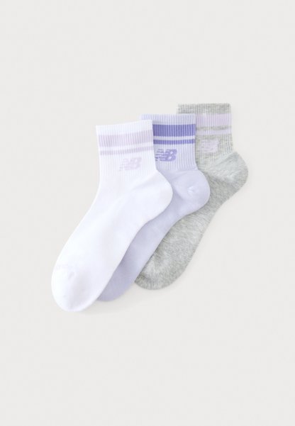 Tres calcetines tobilleros en blanco, lila claro y gris con rayas a juego y un logo de New Balance en los puños.
