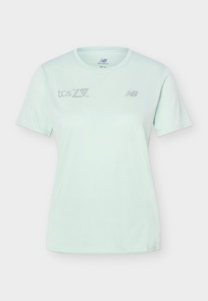 Camiseta deportiva de manga corta azul claro con los logotipos de New Balance y TCS en el pecho, con escote redondo y corte entallado.