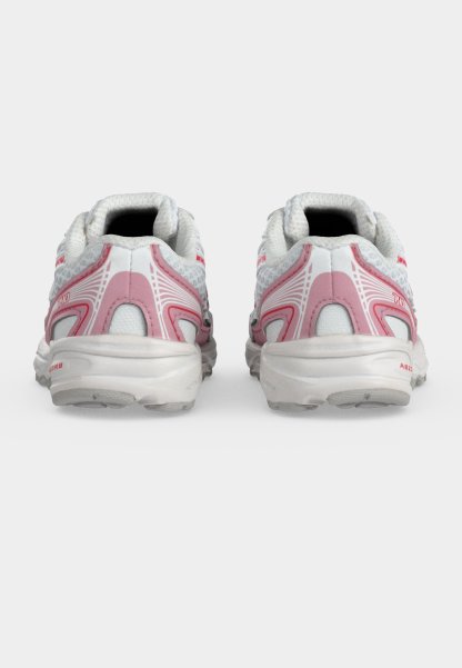 Par de zapatillas de deporte blancas y rosas vistas desde atrás sobre un fondo claro y liso.