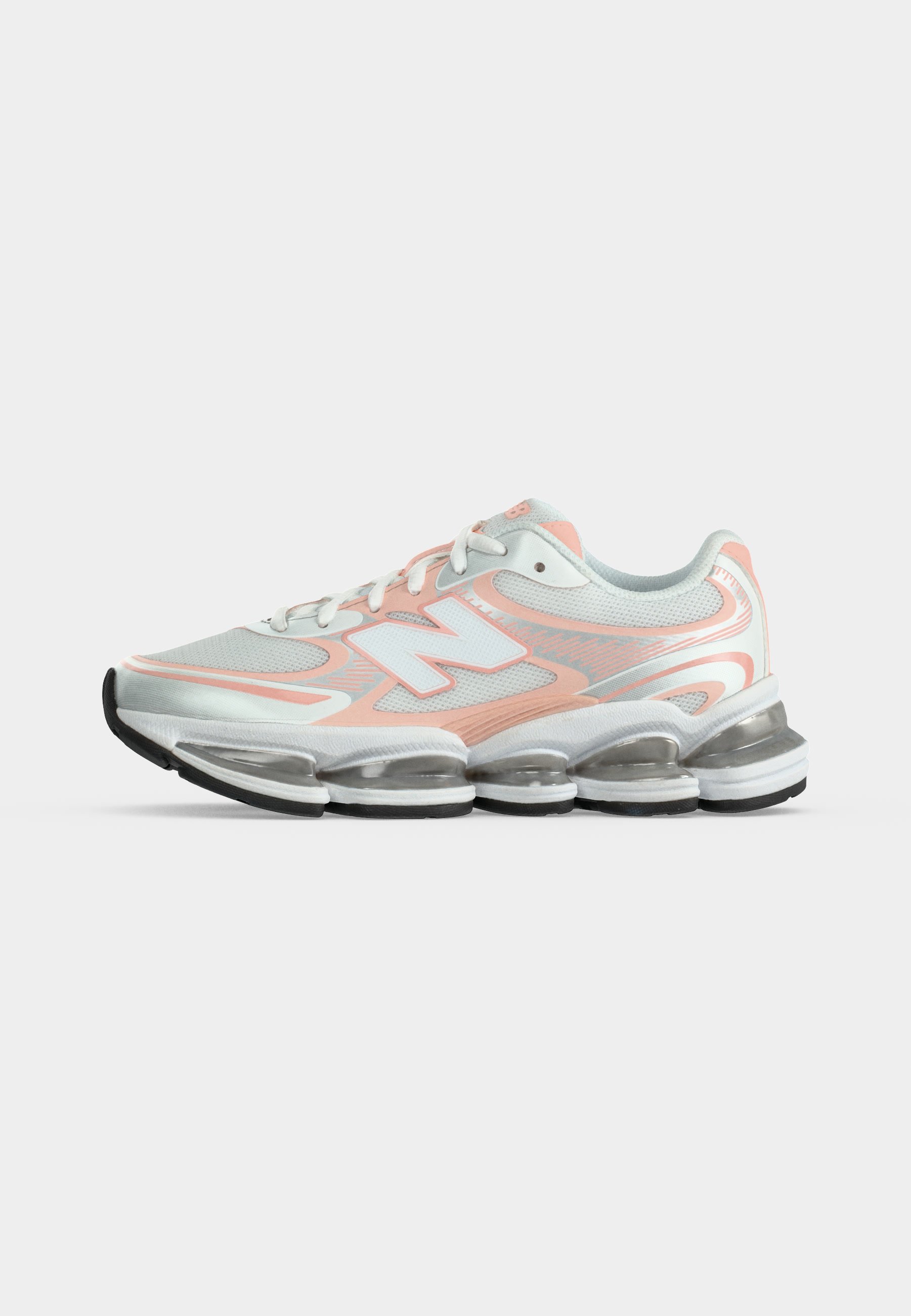 Zapatilla deportiva blanca y melocotón con cordones delanteros, parte superior de malla y suela gruesa transparente segmentada.