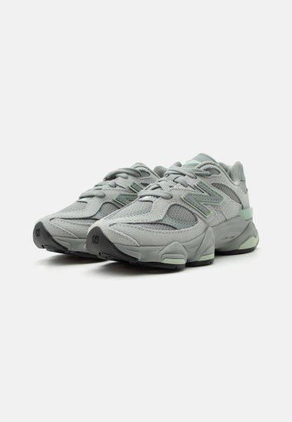 Par de zapatillas deportivas New Balance en gris claro y verde menta con parte superior de malla y ante, suelas gruesas y cordones sobre fondo blanco.