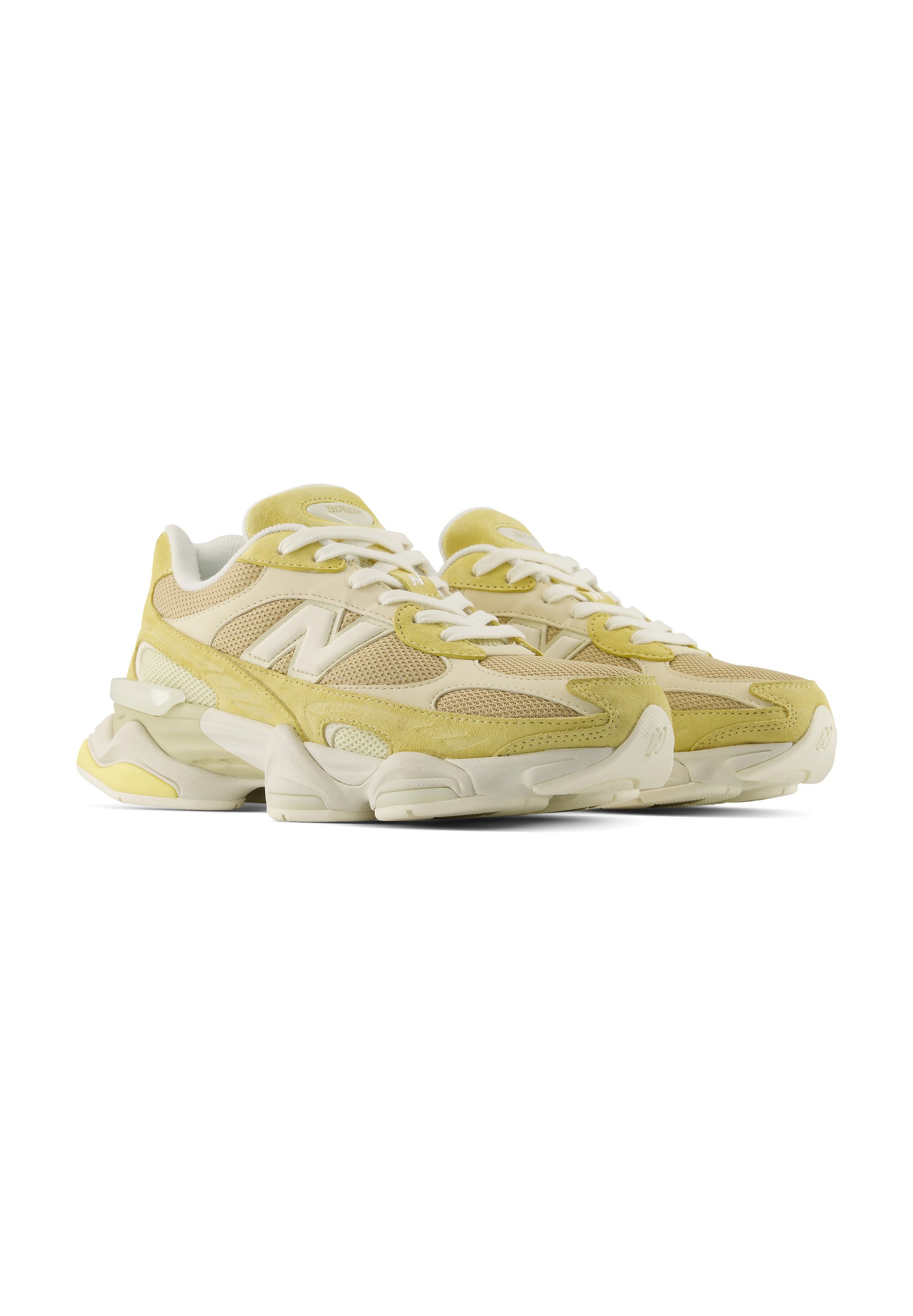 Par de zapatillas deportivas amarillas y beige con cordones blancos y suelas blancas gruesas, colocadas una al lado de la otra mirando hacia la derecha.