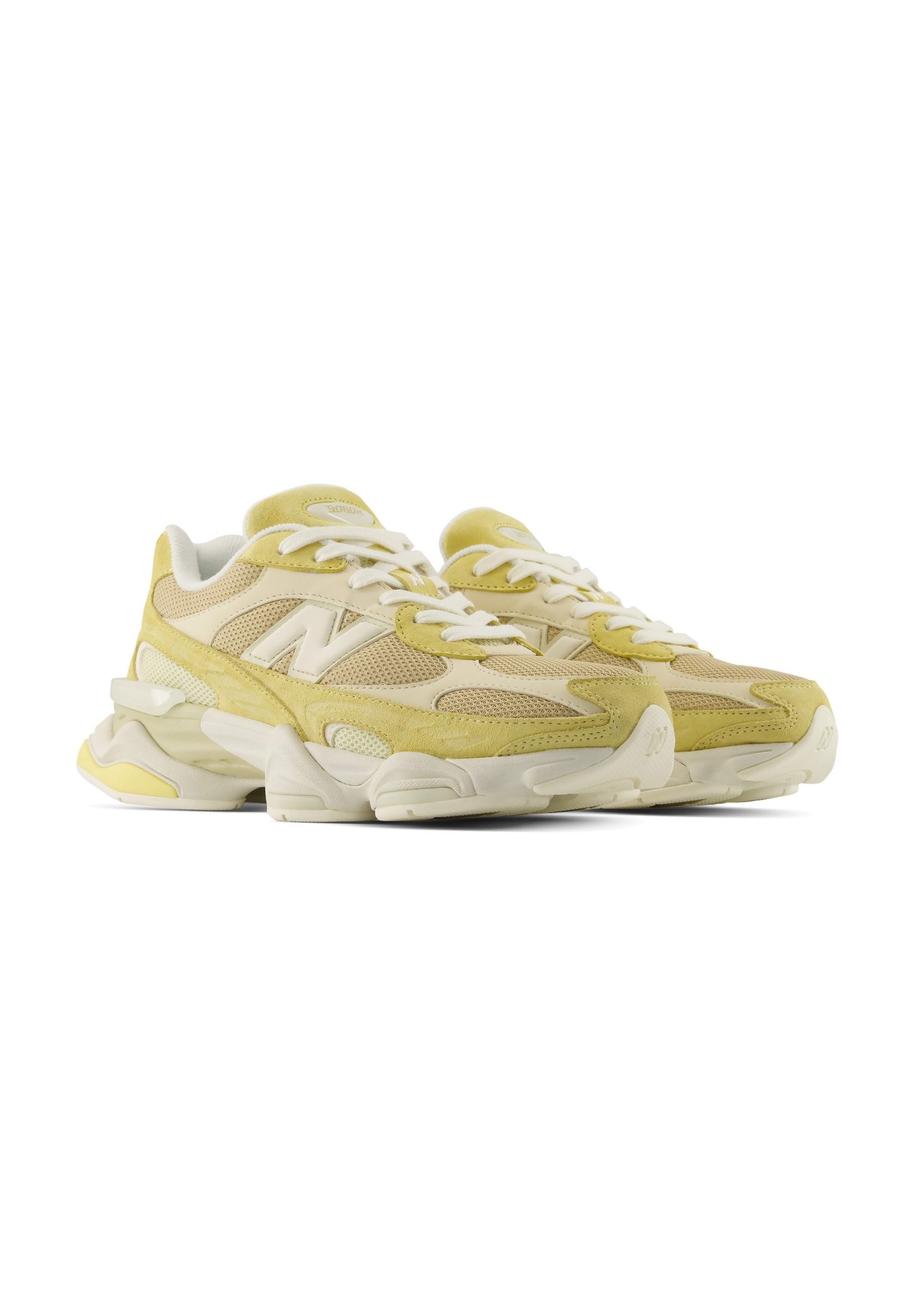 Par de zapatillas deportivas amarillas y beige con cordones blancos y suelas blancas gruesas, colocadas una al lado de la otra mirando hacia la derecha.