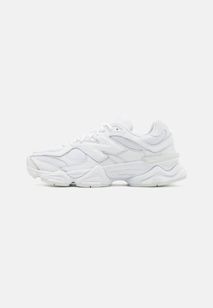 Zapatillas deportivas blancas con una parte superior de malla y cuero, punta redondeada, diseño en capas y suela acolchada para mayor comodidad.
