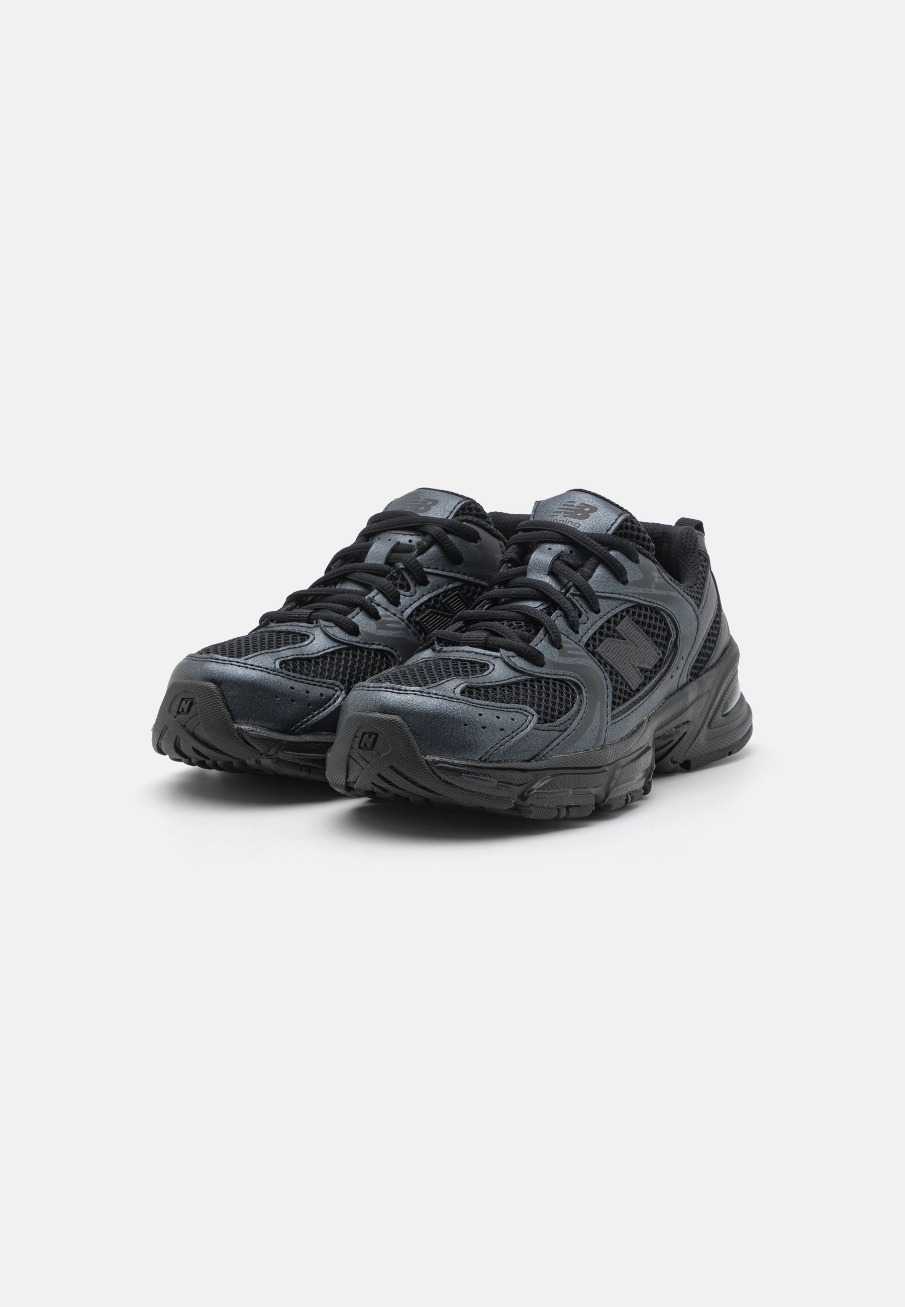 Zapatillas deportivas negras con parte superior de malla y sintético, collar acolchado, cordones y suela de goma texturizada, con un logo en la lengüeta.