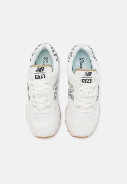 Par de zapatillas blancas New Balance 574 con detalles de estampado de leopardo en los lados y alrededor del cuello, vistas desde arriba.