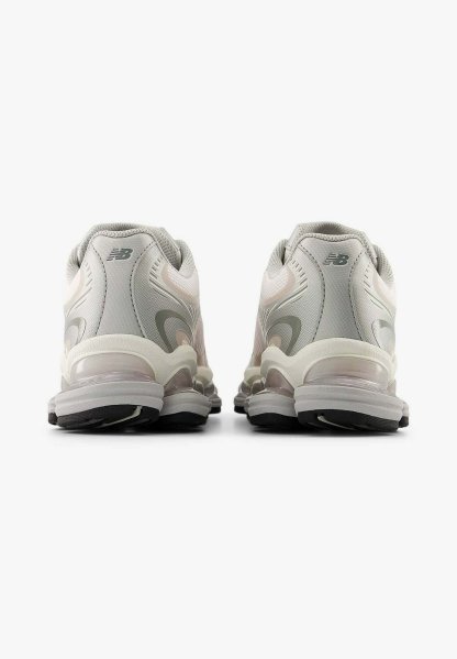 Par de zapatillas deportivas New Balance en color gris y blanco mostradas desde el talón, con suelas gruesas que cuentan con amortiguación visible y suelas exteriores negras.
