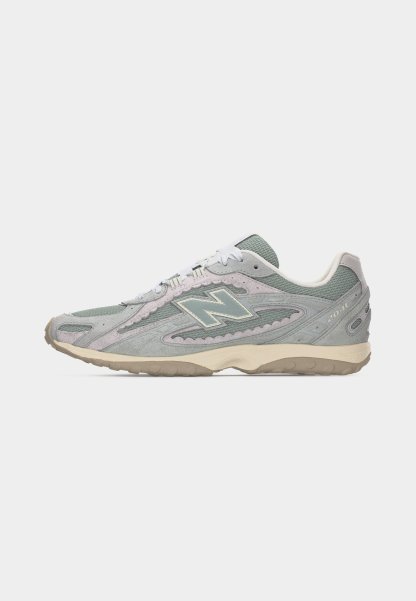 Zapatilla New Balance 2041 de color gris y beige con parte superior de malla y ante, cordones blancos y suela de goma, vista desde el lado derecho.