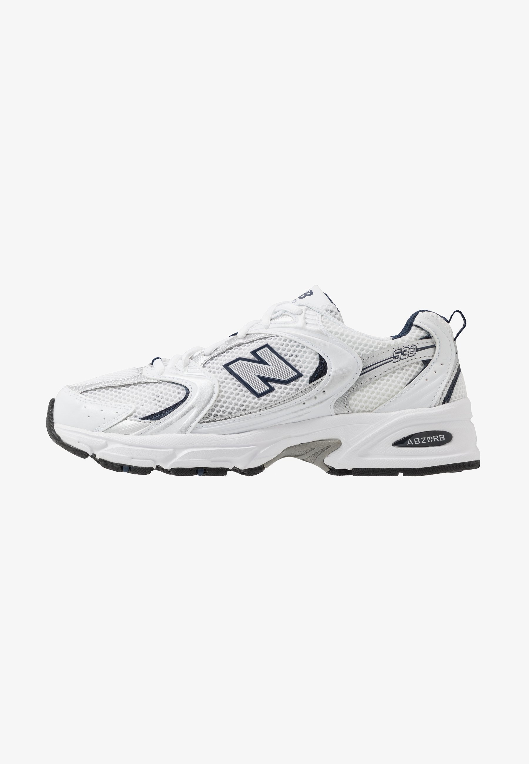 Zapatilla deportiva blanca con parte superior de malla, acentos en azul marino y suela acolchada. Presenta el logo "N", cordones y detalle texturizado en el lateral.