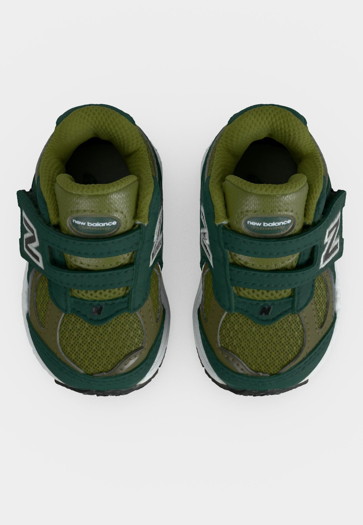 Par de zapatillas para niños pequeños New Balance verdes y verde oscuro con tiras de velcro y tejido de malla, mostradas desde arriba sobre un fondo blanco.