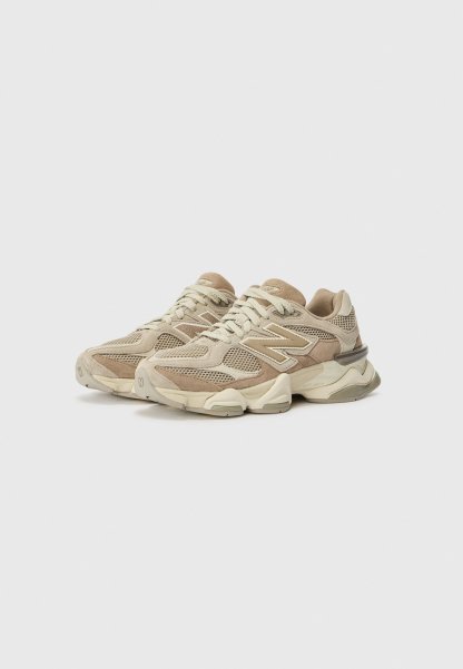Zapatillas de malla y ante beige con detalles texturizados. Cierre con cordones, punta redondeada y suela acolchada. Presenta un logo en el lateral.