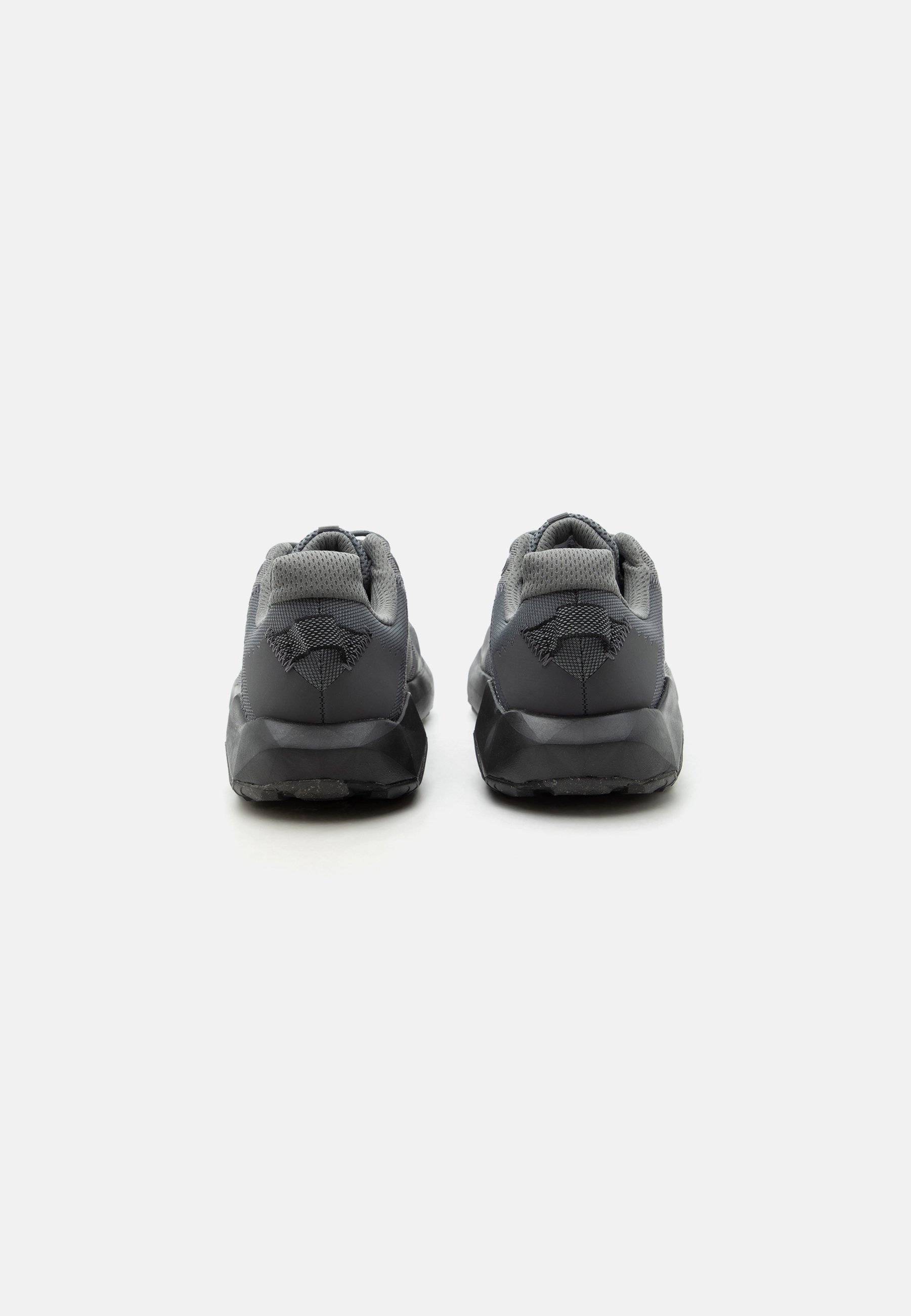 Par de zapatillas deportivas negras y grises vistas desde atrás con cuellos acolchados y detalles de tela texturizada sobre un fondo blanco.