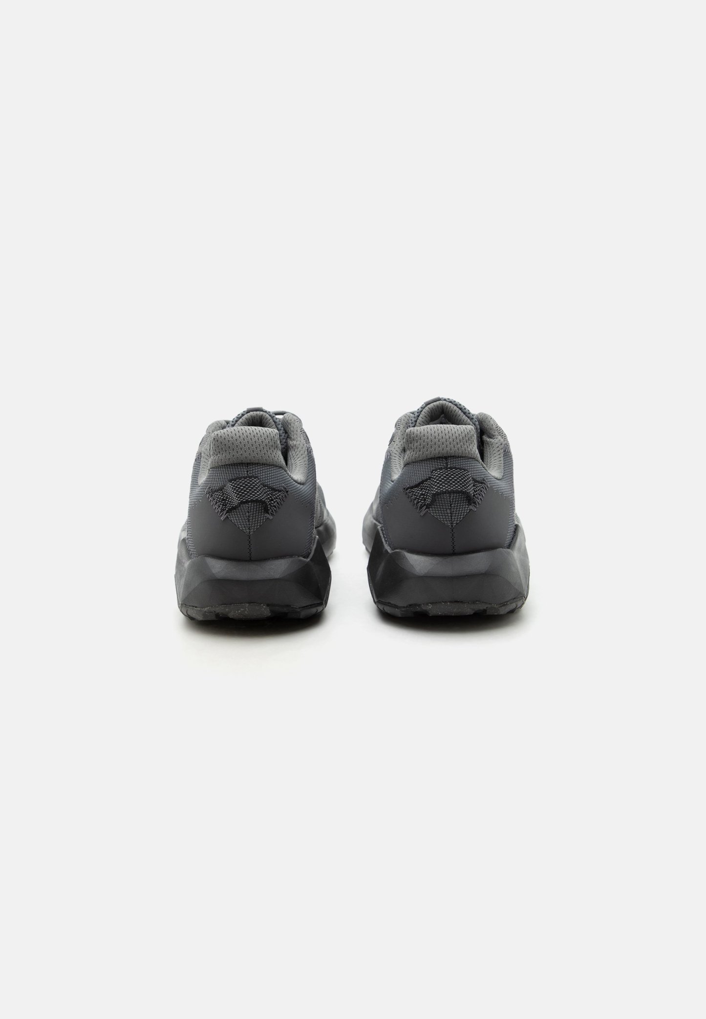 Par de zapatillas deportivas negras y grises vistas desde atrás con cuellos acolchados y detalles de tela texturizada sobre un fondo blanco.