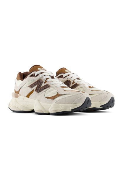 Par de zapatillas New Balance beige y marrón con cordones blancos y suelas gruesas color crema sobre un fondo blanco.