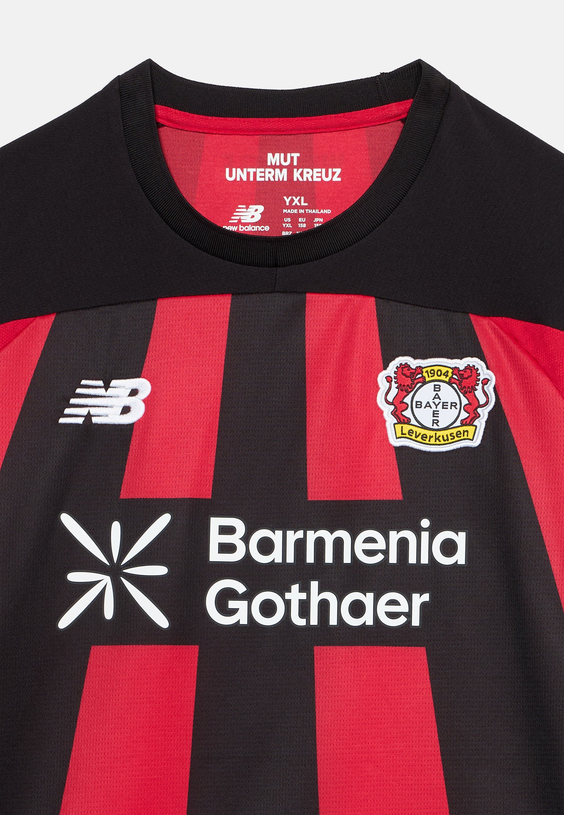 Camiseta de fútbol a rayas negras y rojas con el logo de Bayer Leverkusen, logo de New Balance y texto del patrocinador Barmenia Gothaer en el frente.