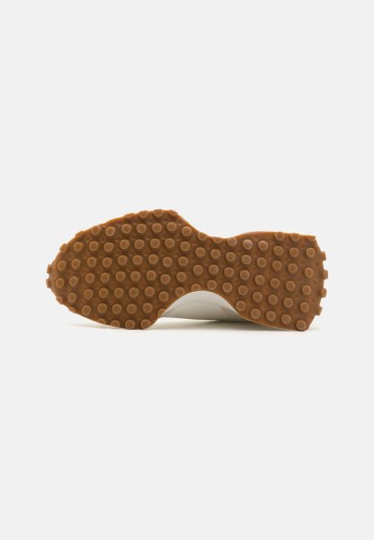 Suela de zapato con una superficie de goma marrón texturizada que presenta patrones circulares. Parte superior blanca lisa visible en los bordes. Diseño limpio y plano.