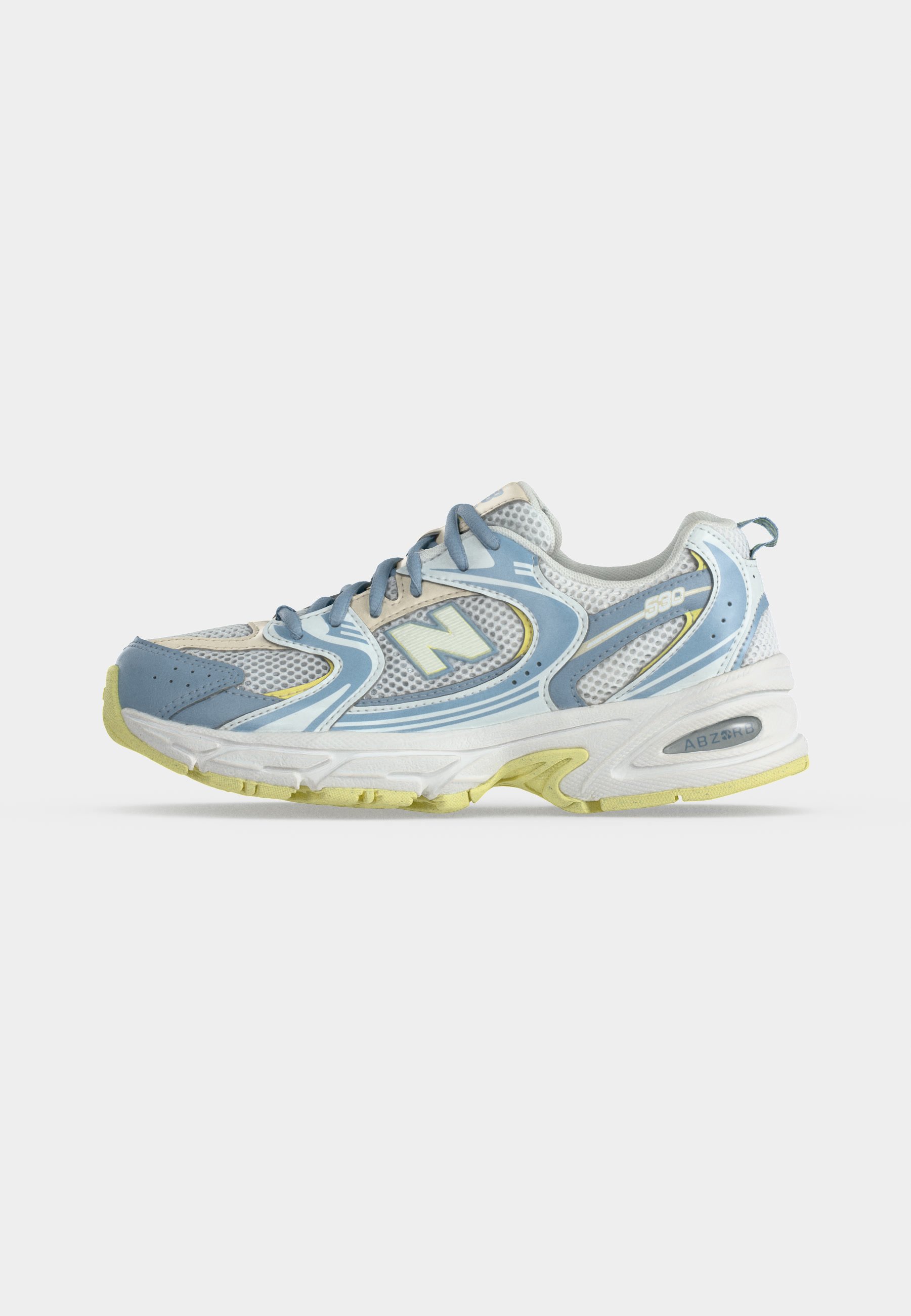 Una única zapatilla de correr New Balance azul claro y blanca con detalles amarillos en la suela y detalles de tela de malla sobre un fondo liso.