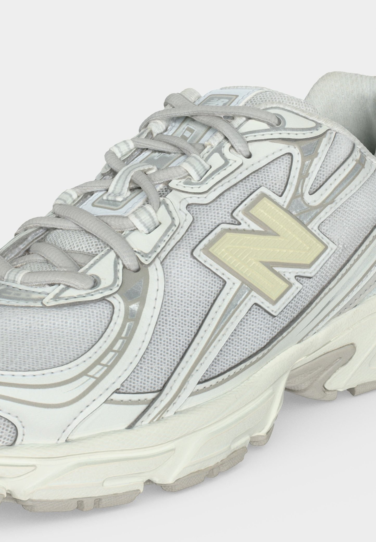 Zapatilla deportiva blanca y gris con tejido de malla, cierre con cordones y gran logo "N" en el lateral.