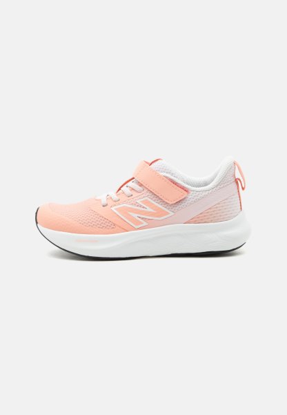 Zapatilla deportiva rosa y blanca con parte superior de malla, cierre de velcro, cordones blancos, suela acolchada y una lengüeta en el talón.