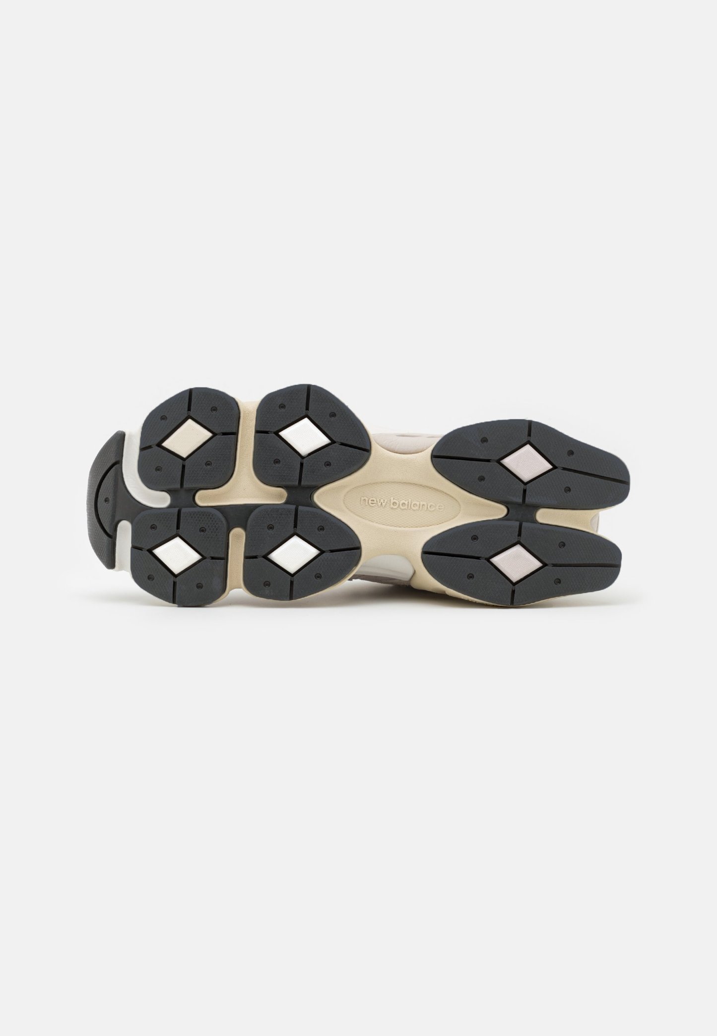 Suela de calzado con un patrón de tracción de goma negra, entresuela beige claro y acentos hexagonales. La textura es suave, con colores contrastantes.