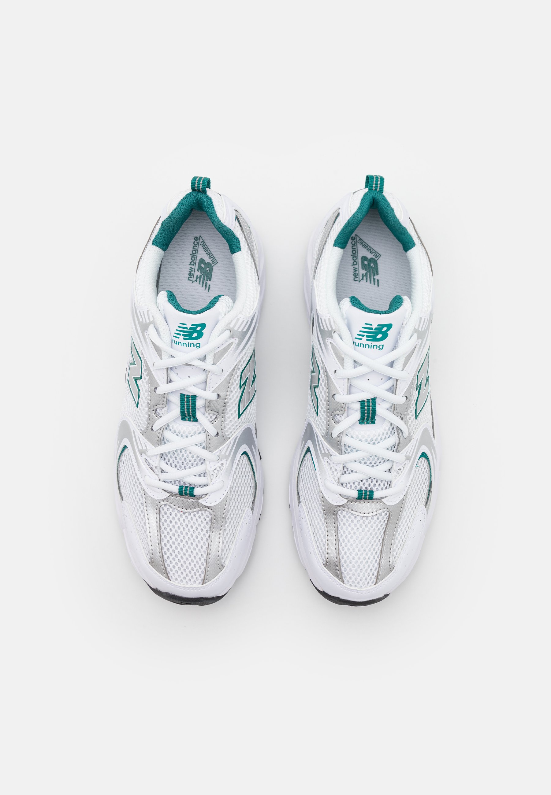 Zapatillas deportivas blancas con acentos en azul verdoso, parte superior de malla, cuello acolchado y suela de goma gruesa. Presentan elementos reflectantes y detalles del logo.