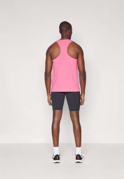 Top de tirantes rosa con un diseño de espalda nadadora, combinado con pantalones cortos negros. La tela parece ligera y de textura suave.