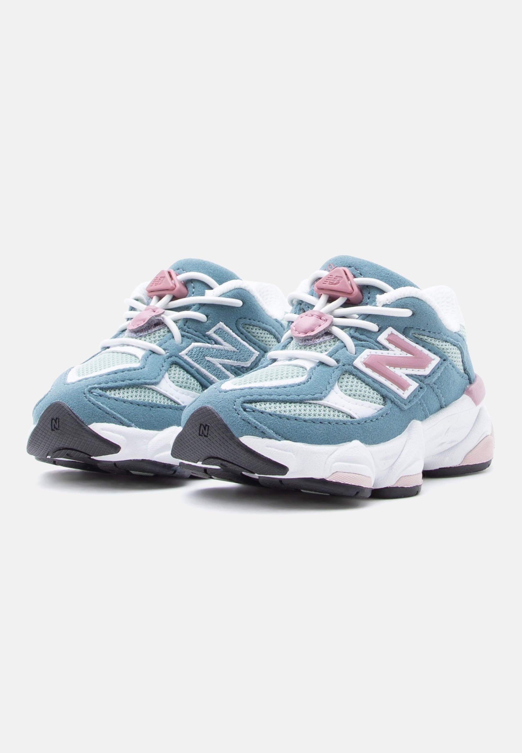 Par de zapatillas deportivas azul y blanco con detalles rosas y cordones elásticos blancos, colocadas lado a lado sobre un fondo blanco.