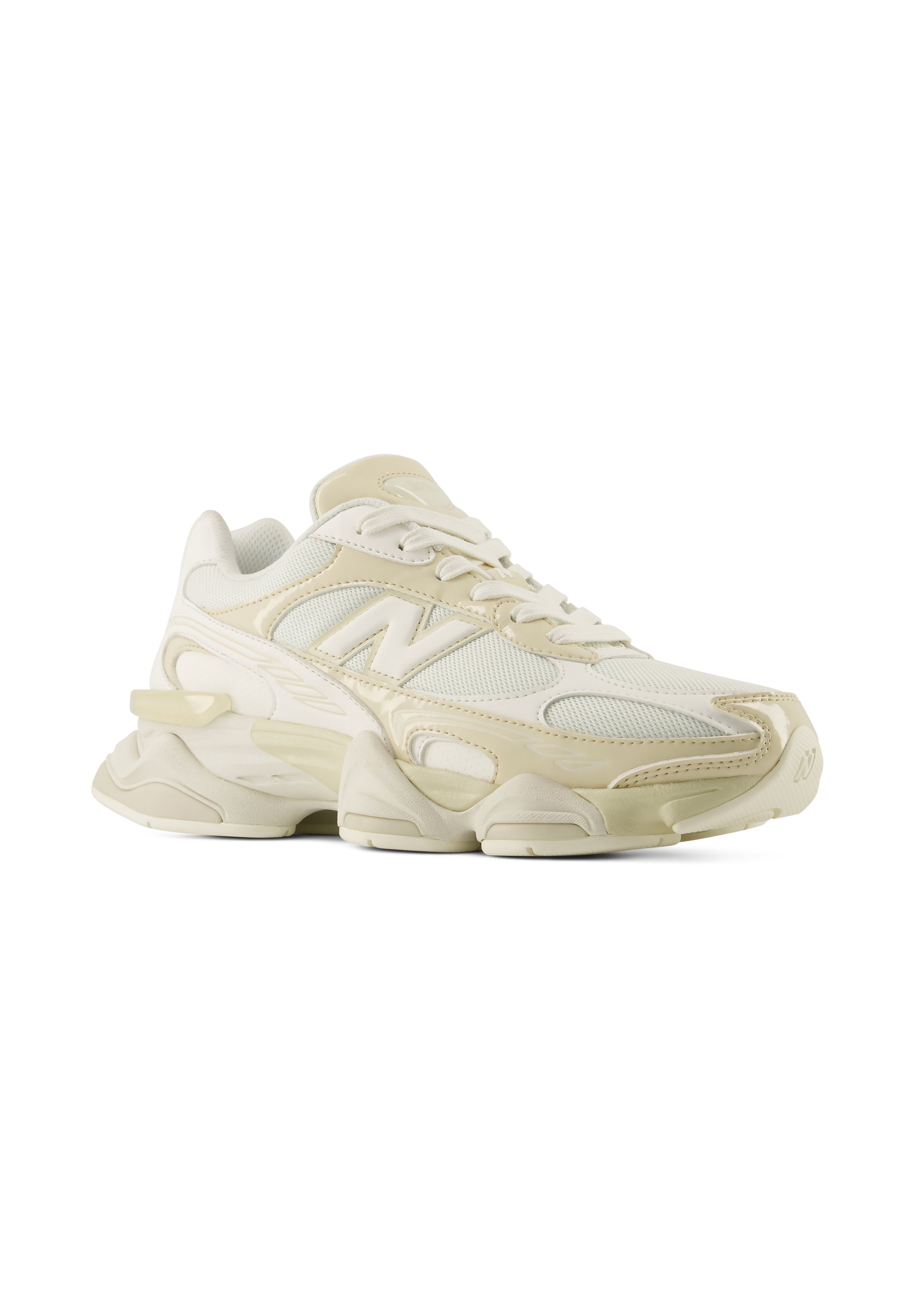 Zapatilla deportiva de color crema con paneles de malla y piel, suela gruesa acolchada y cierre con cordones, mostrada en un ligero ángulo lateral.