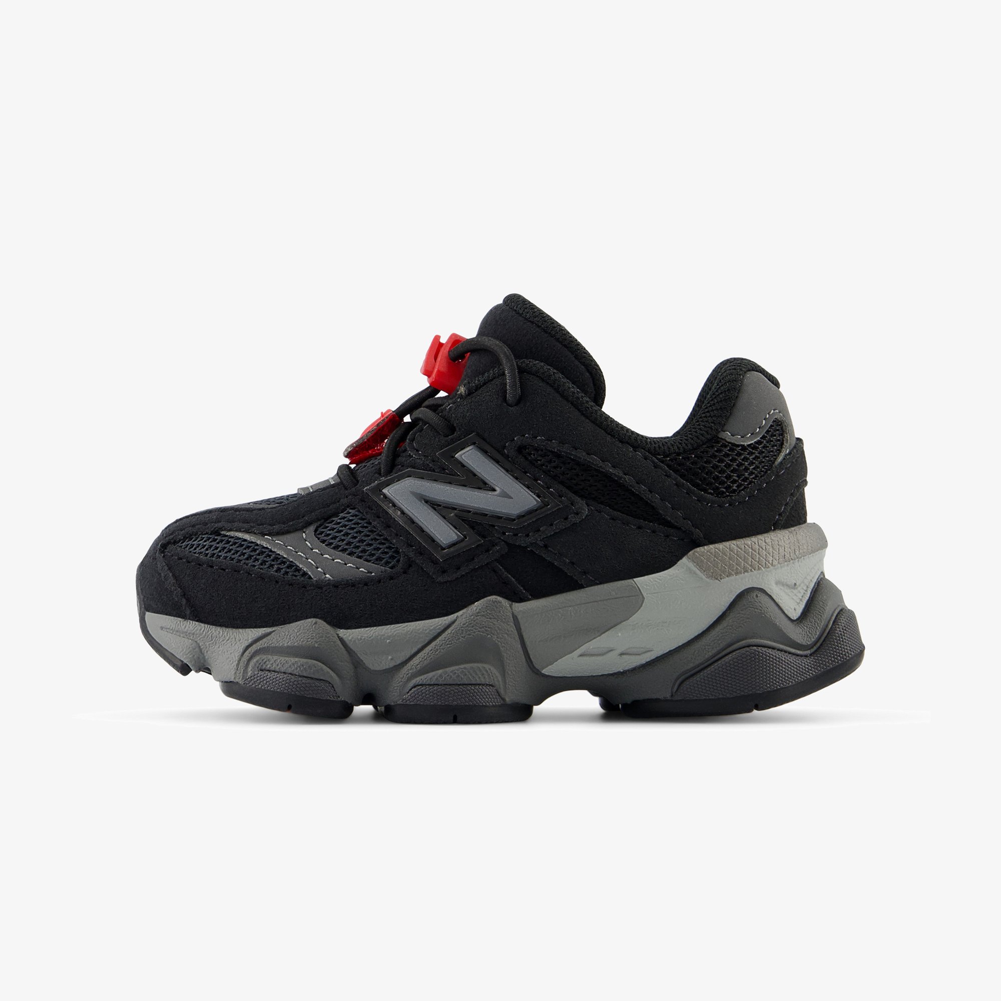Zapatillas deportivas negras con acentos grises, con una parte superior texturizada, paneles de malla y cierre de cordón con toggle rojo. Suela gruesa y acolchada.